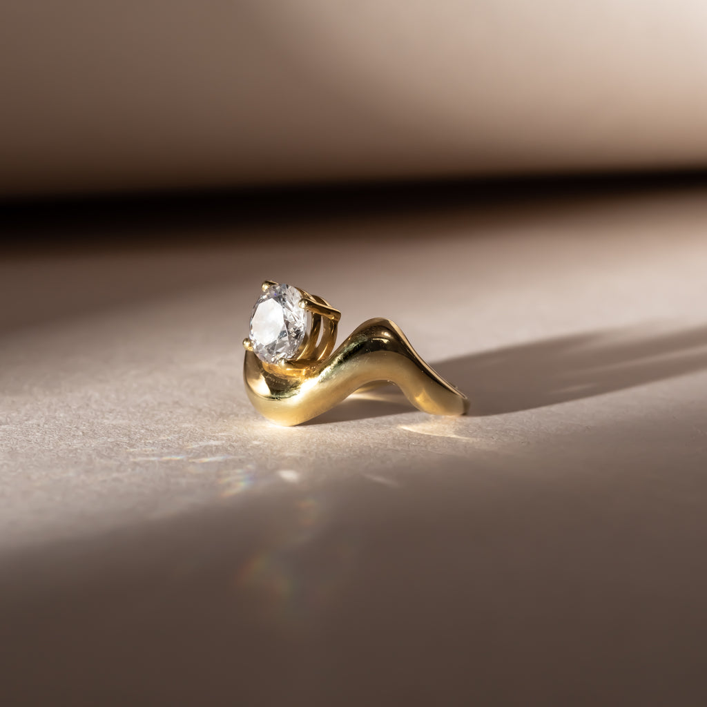 Engagement style diamond ring with yellow gold wave shaped band