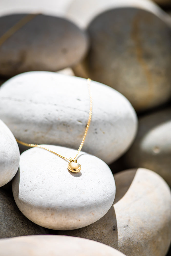 Gold pebble pendant necklace