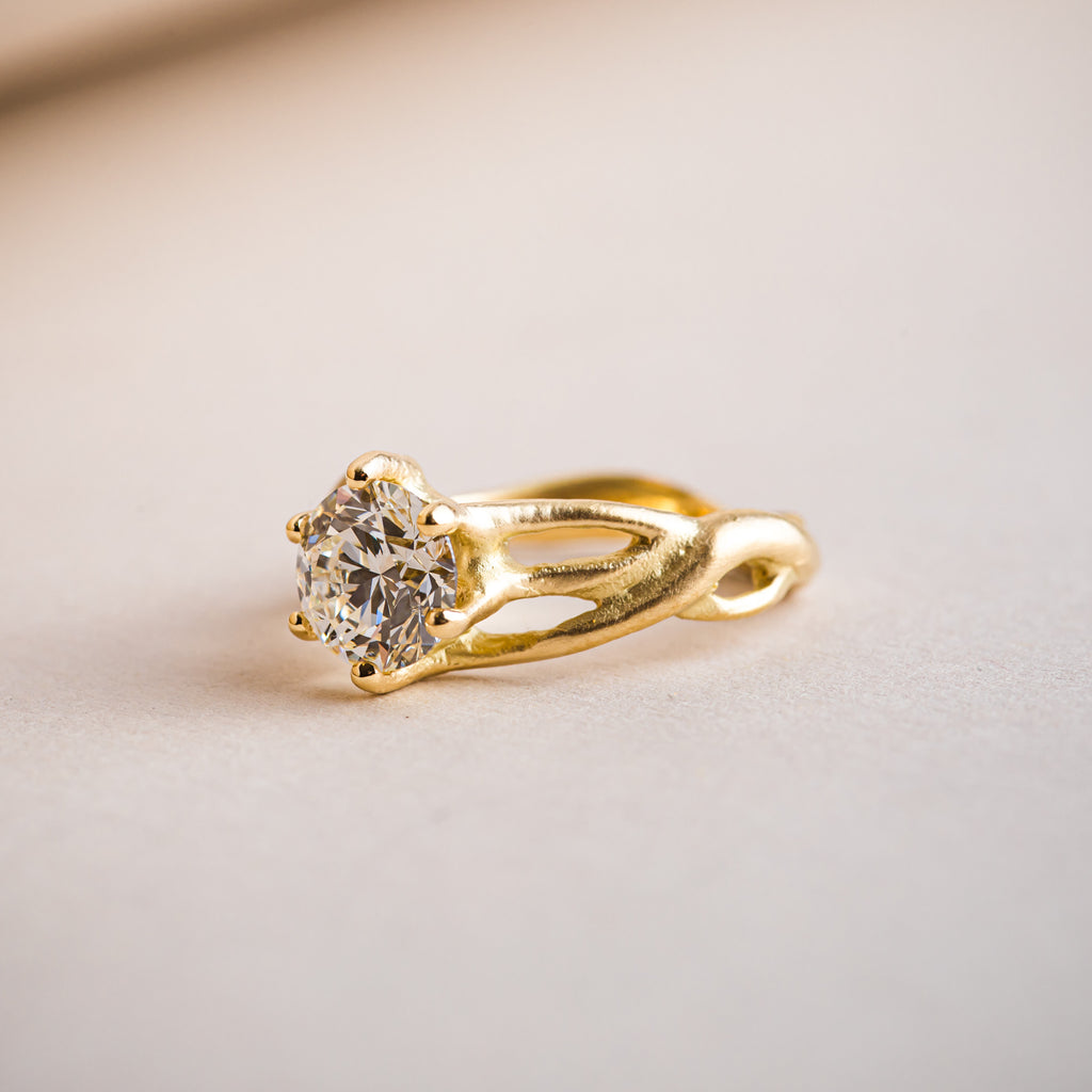 Canadian brilliant round diamond set within a natural, organic weaving 18ct yellow gold ring. 